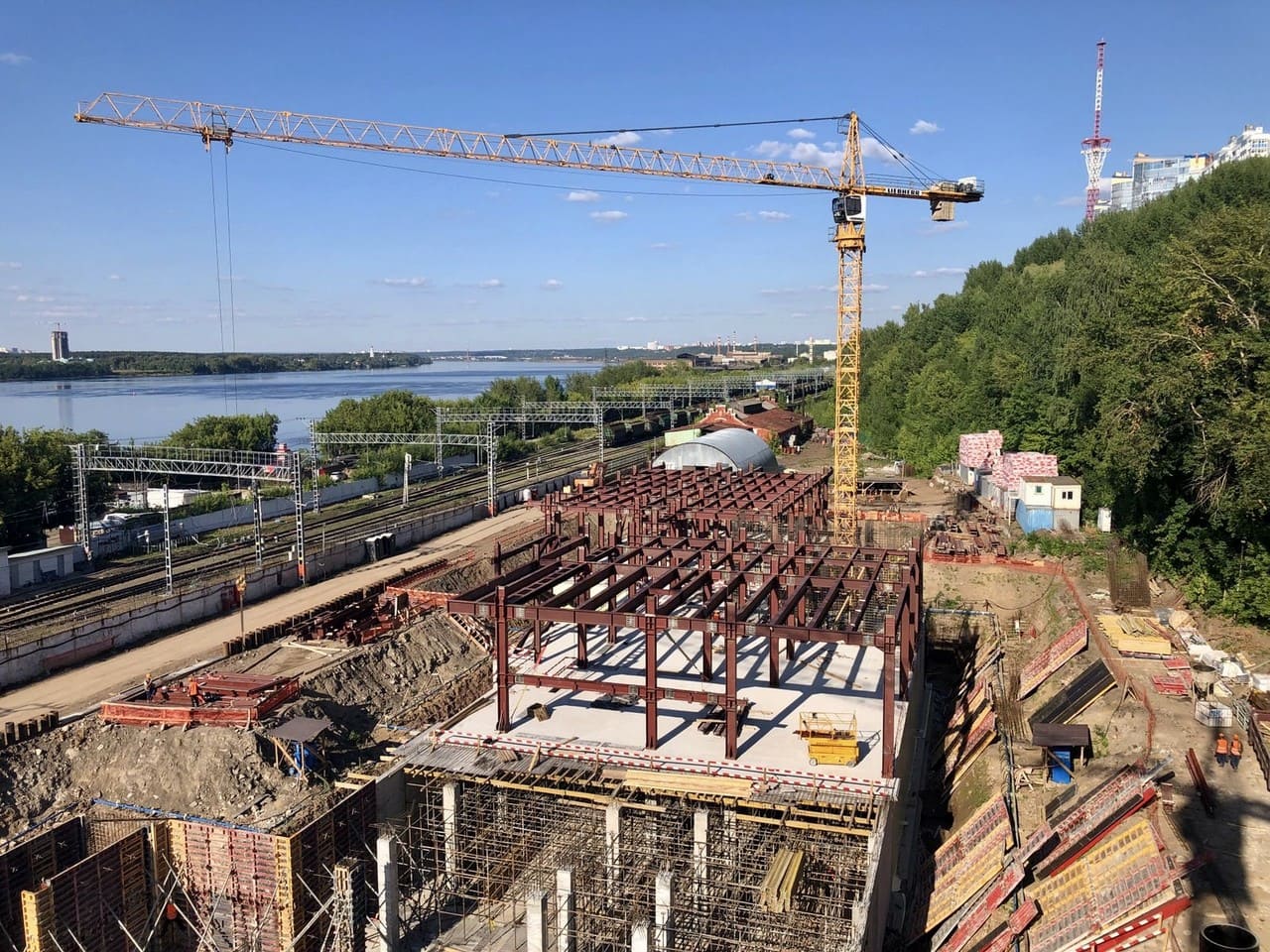 На площади строители возводят здание нового. Постройка завода. Строительство завода. Начало стройки. Новое здание.